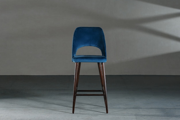 Free Photo blue dining room chair in a studio with gray walls