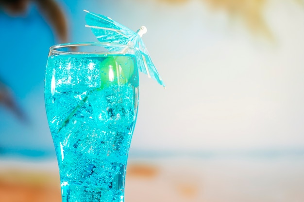 Free photo blue drink with ice cubes in umbrella decorated glass