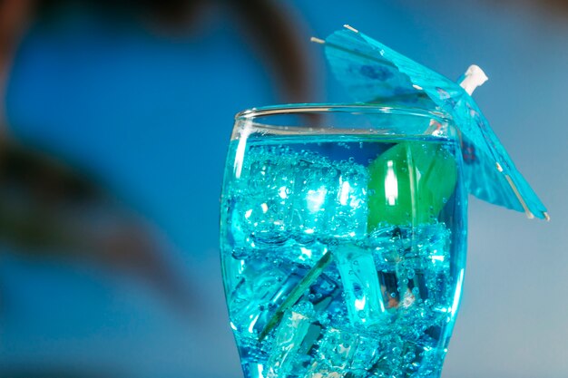 Blue drink with mint in umbrella decorated glass