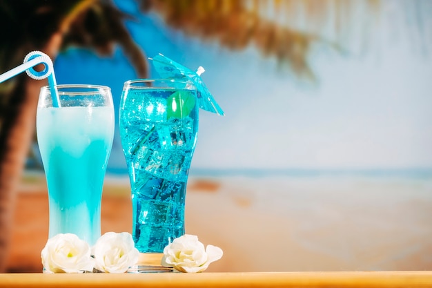 Free Photo blue drinks with straw in umbrella decorated glasses and flowers