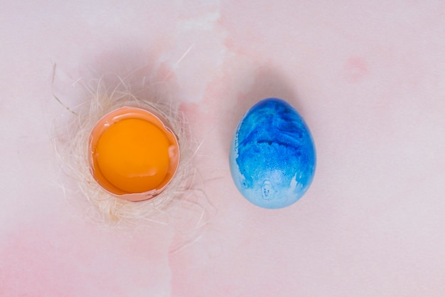 Free photo blue easter egg with broken egg in nest