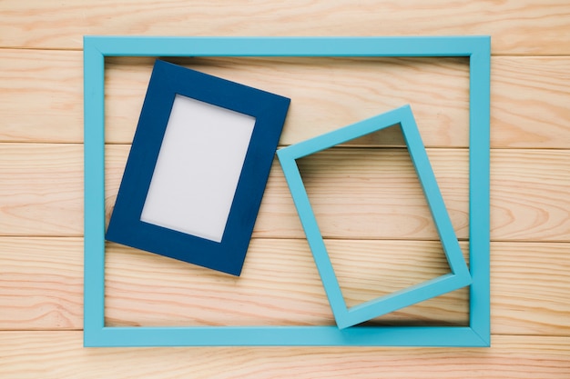 Blue empty frames on wooden background