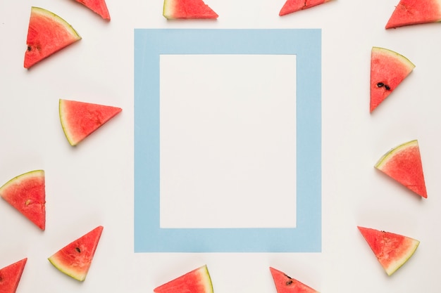 Free Photo blue frame and sliced juicy water melon on white surface