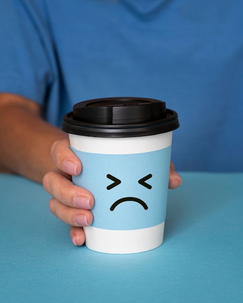 Blue monday concept with sad face on cup