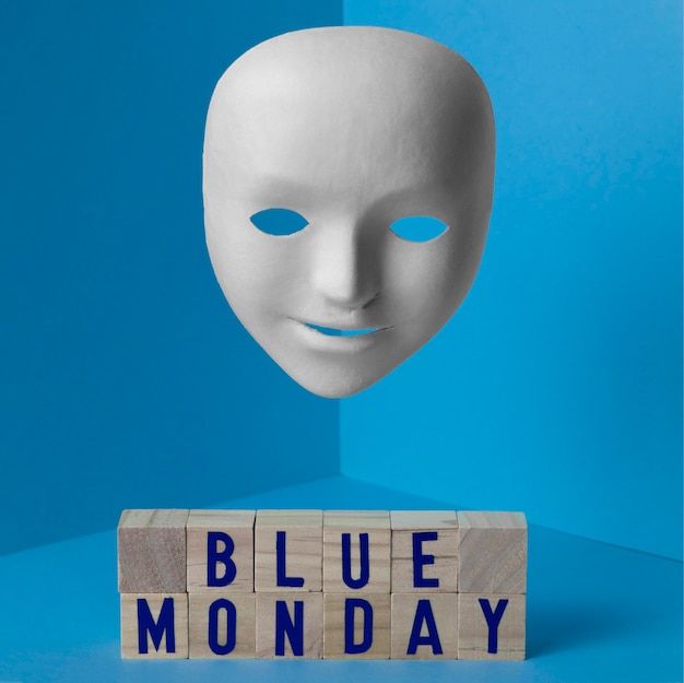 Free photo blue monday with face mask and wooden cubes