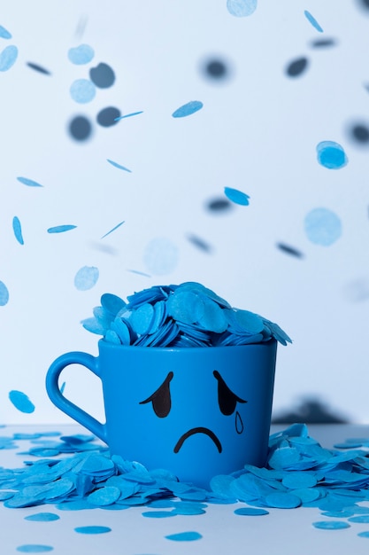 Free Photo blue monday with teary mug and paper rain