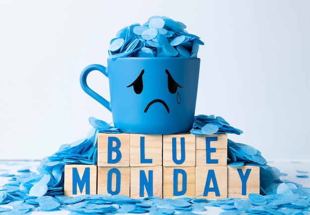 Free photo blue monday with wooden cubes and crying mug