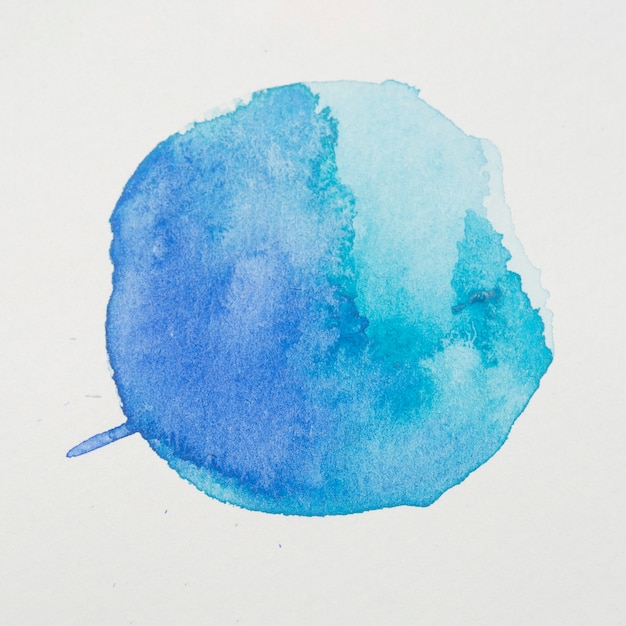 Blue paints in form of circle on white paper