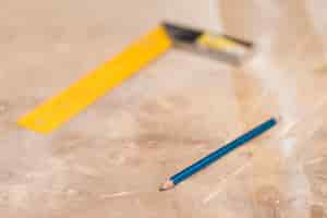 Free photo blue pencil and blurred ruler on wooden surface