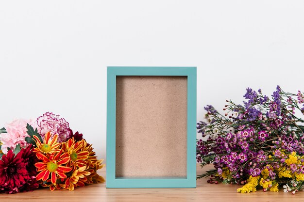 Blue picture frame surrounded with flowers