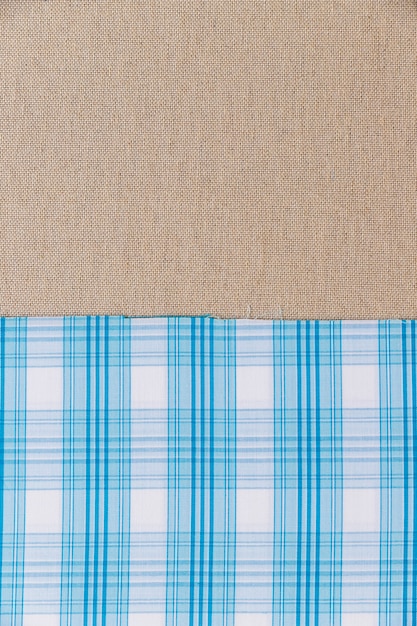 Free photo blue plaid pattern textile on plain sack cloth