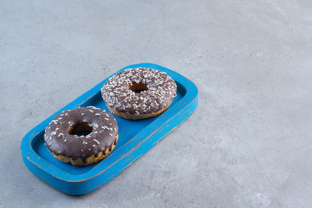 Free Photo blue plate of tasty chocolate donuts on stone.