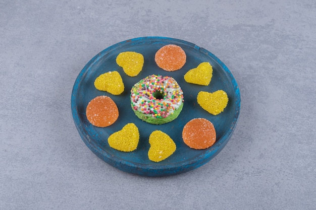 Free photo blue platter with a small donut and various marmelades on marble surface`