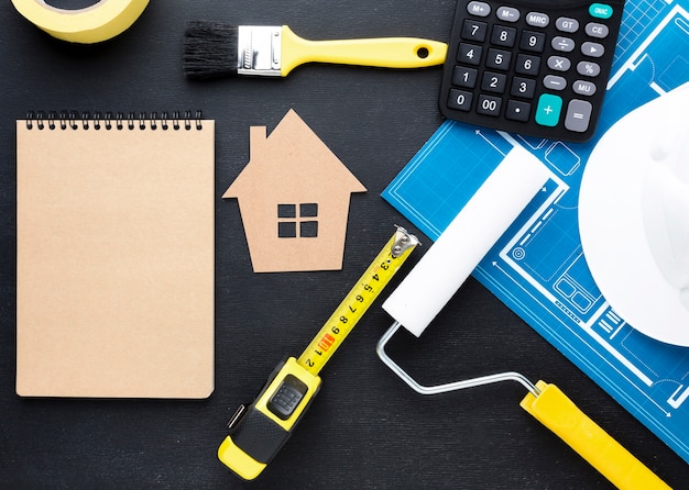 Free photo blue print of a house with tools and empty notepad