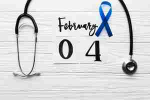 Free photo blue ribbon between stethoscope and date