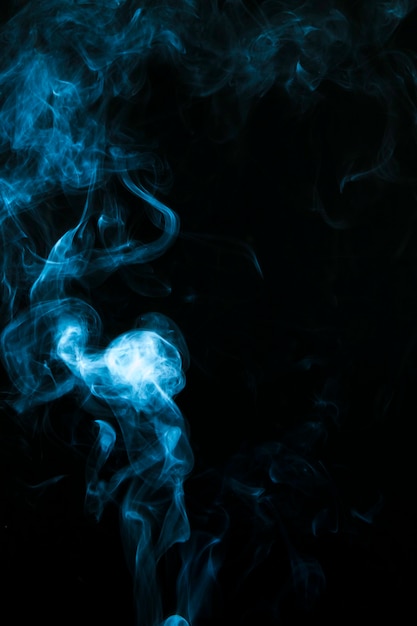 Free photo blue smoke clouds over black background