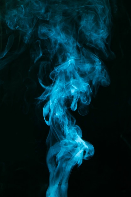 Free Photo blue smoke spread on black background