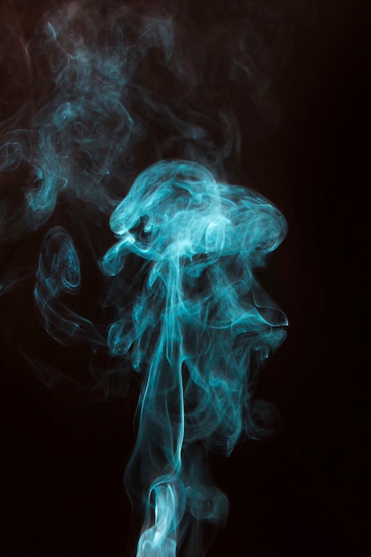 Free photo blue smoke spread on black background