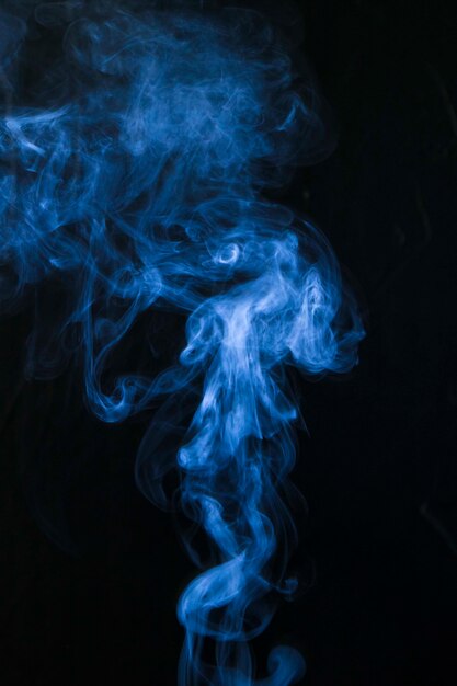 Blue smoke twirling on black background