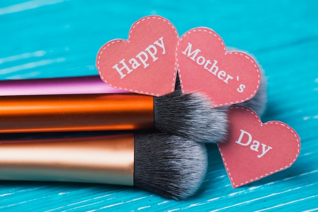 Free photo blue surface with hearts and make-up brushes