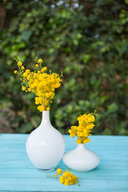 Free photo blue surface with vases and yellow flowers