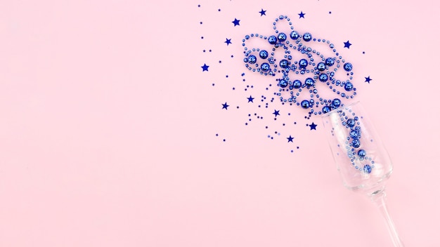 Free photo blue tinsel in a glass on pink copy space background