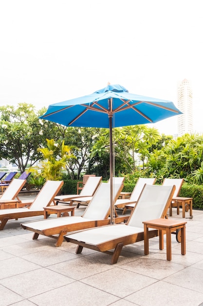 Blue umbrella with some deck chairs