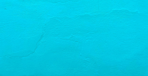 A blue wall with a rough textured surface.