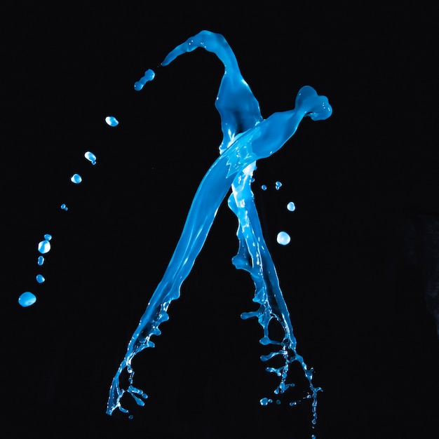 Free photo blue water splashing against black backdrop