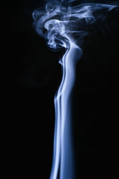 Free photo blue wavy smoke on black background