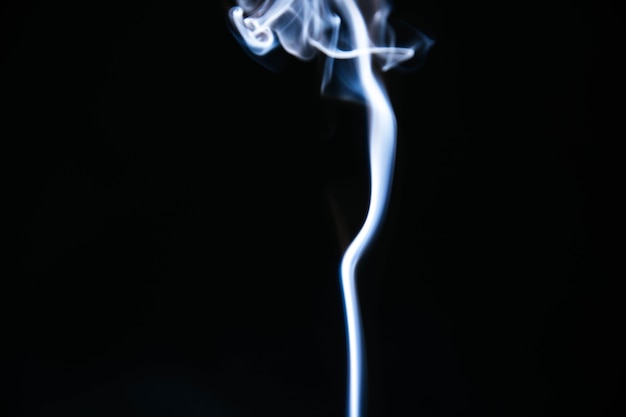 Free photo blue wavy smoke on black background