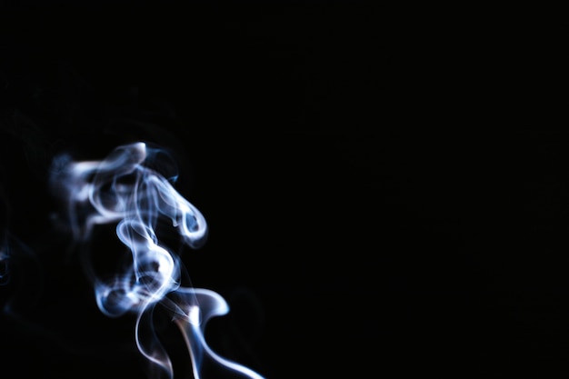 Free photo blue wavy smoke on black background