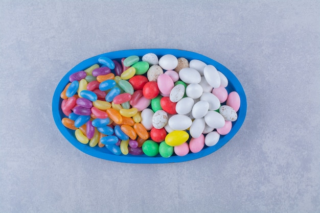 A blue wooden board of colorful sweet jelly bean candies 