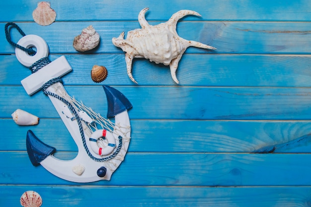 Free Photo blue wooden surface with seashells and anchor