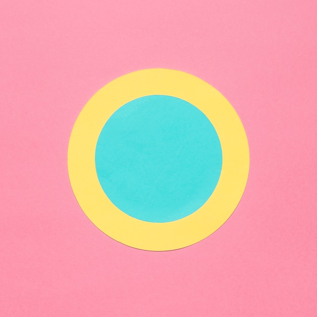 Free Photo blue and yellow circular frame on pink background