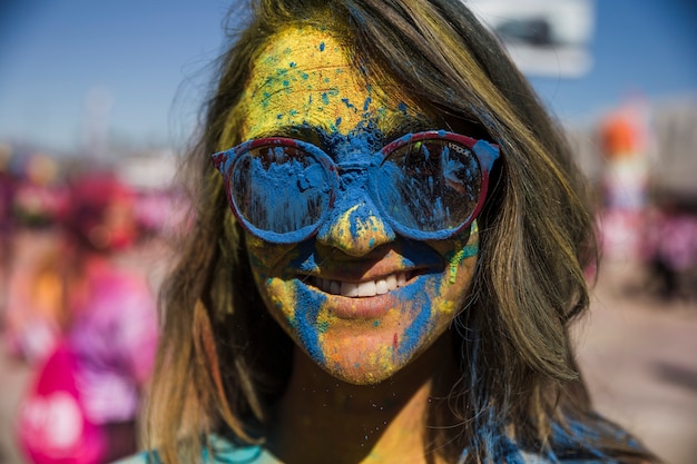 Blue and yellow holi color powder on woman's face