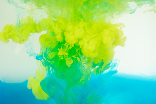 Free photo blue and yellow paint mixing in water