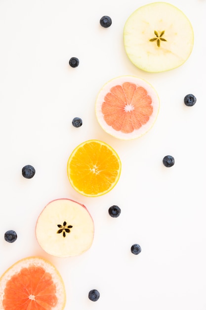 Free Photo blueberries decorated with slices of apple; orange and grapefruit isolated on white backdrop