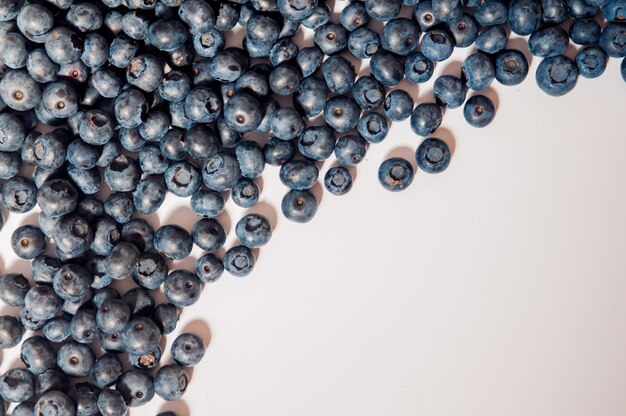 Blueberries isolated on white background. Blueberry border design. Ripe and juicy fresh picked bilberries close up. Copyspace. Top view or flat lay. Tasty blueberries isolated on white background. Blueberries are antioxidant organic superfood.