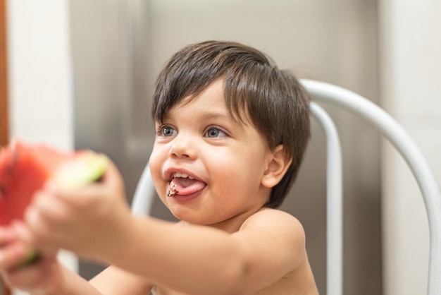 Free photo blueeyed baby boy eating watermelon