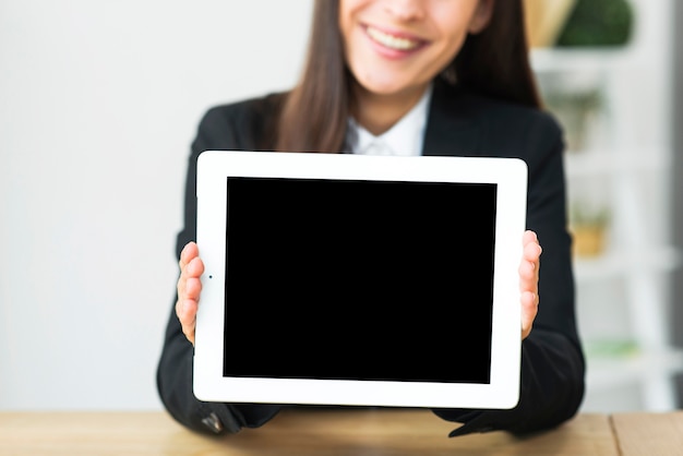 Free photo blur smiling businesswoman showing blank screen display on digital tablet