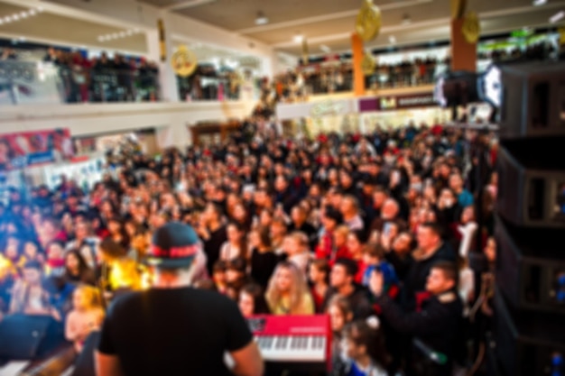 Free photo blured photo crowded concert hall with scene stage lights with people at rock performance