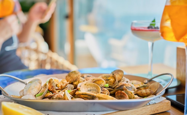 Free photo blurred background with a dish of boiled vongole clams on a table in a cafe with copy space idea for splash screen or banner