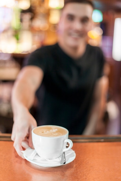 Blurred barista giving coffee