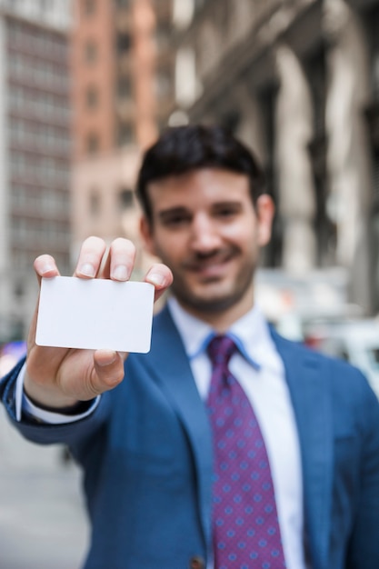 Free photo blurred businessman demonstrating visiting card