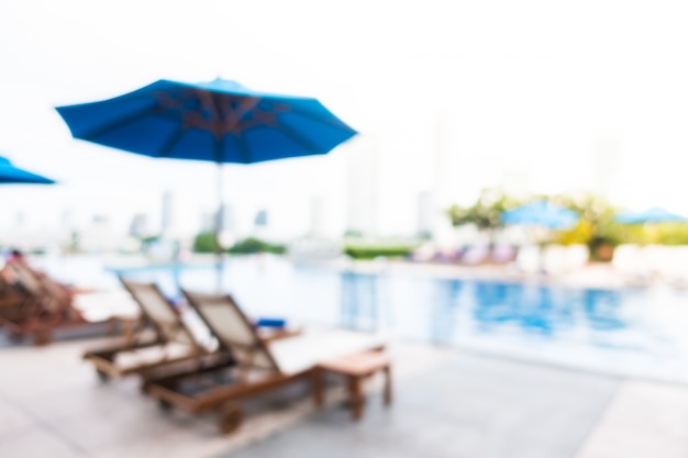 Free photo blurred deck chairs with swimming pool background