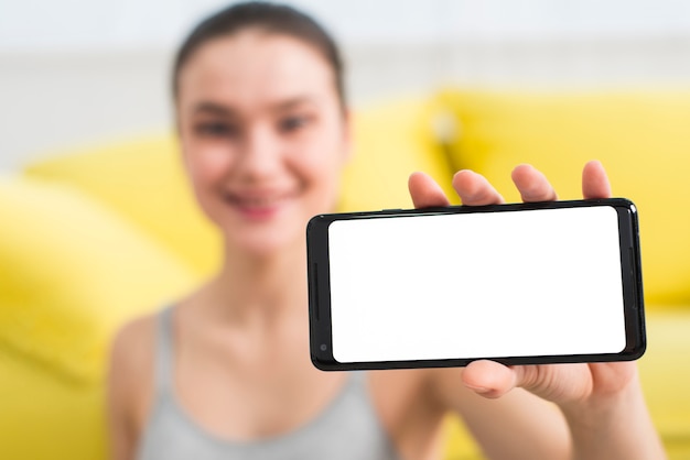 Free photo blurred fitness girl showing mobile phone