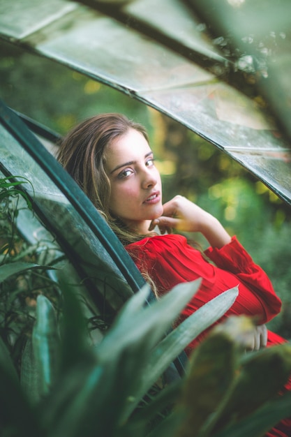 Free photo blurred foliage and woman in a red dress