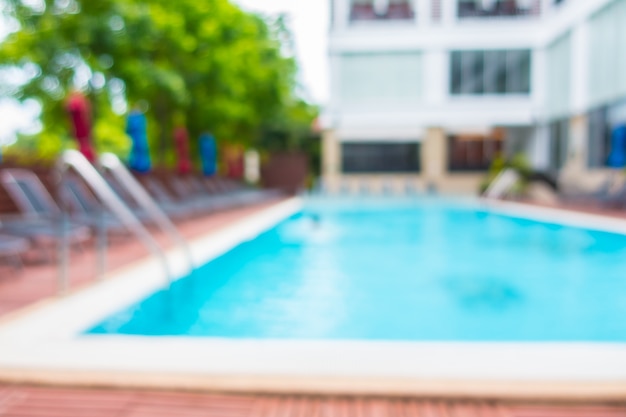 Free photo blurred hammocks with colorful umbrellas in a pool