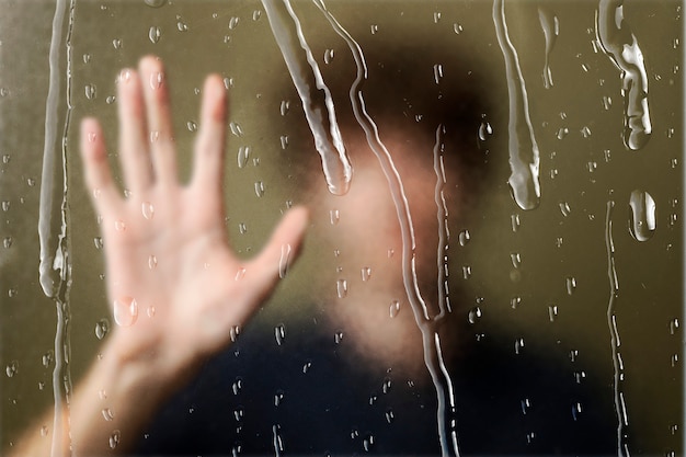 Free Photo blurred man behinds window with rain drops